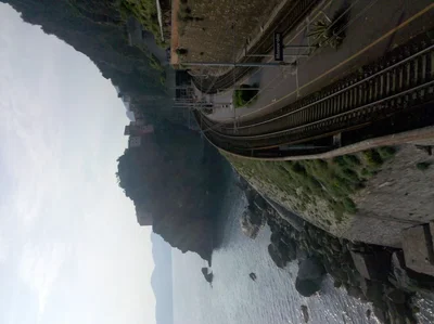curved outdoor escalator beside water and mountains